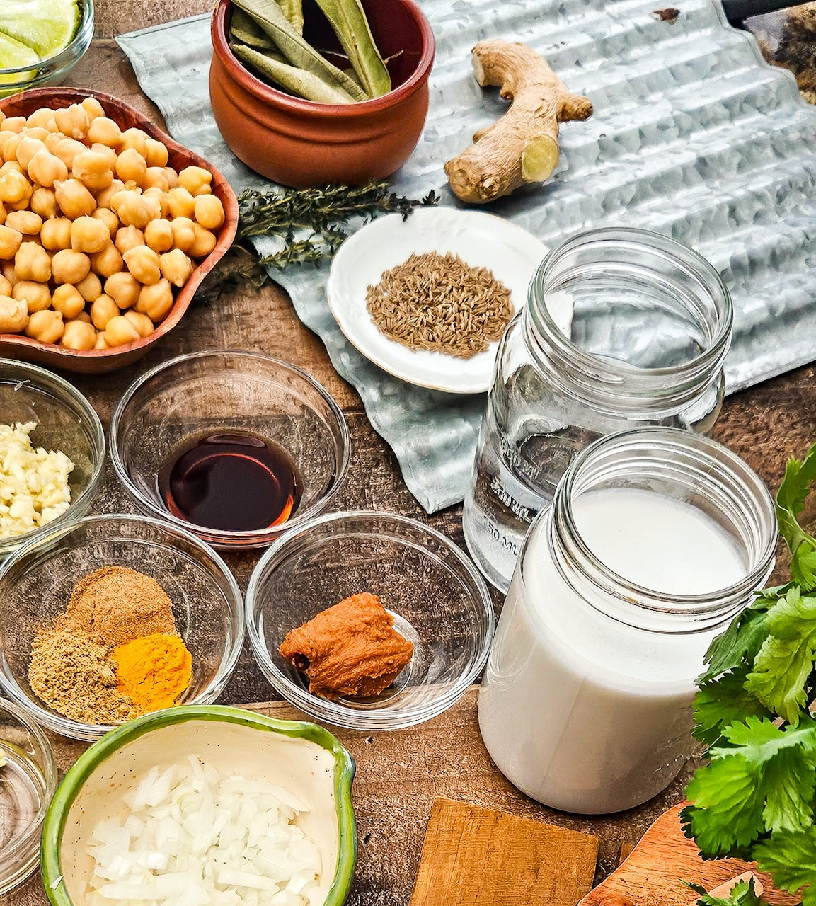Spices, herbs, and ingredients on a wooden table with a rustic background